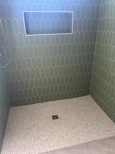 Ducha con azulejo en abanico y piso de mosaico redondo